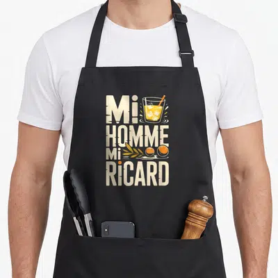 Tablier de cuisine noir avec typographie Mi Homme Mi Ricard et illustration de verre à absinthe.