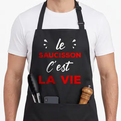 Tablier de cuisine noir avec l'inscription le saucisson c'est la vie en typographie rouge et blanche.