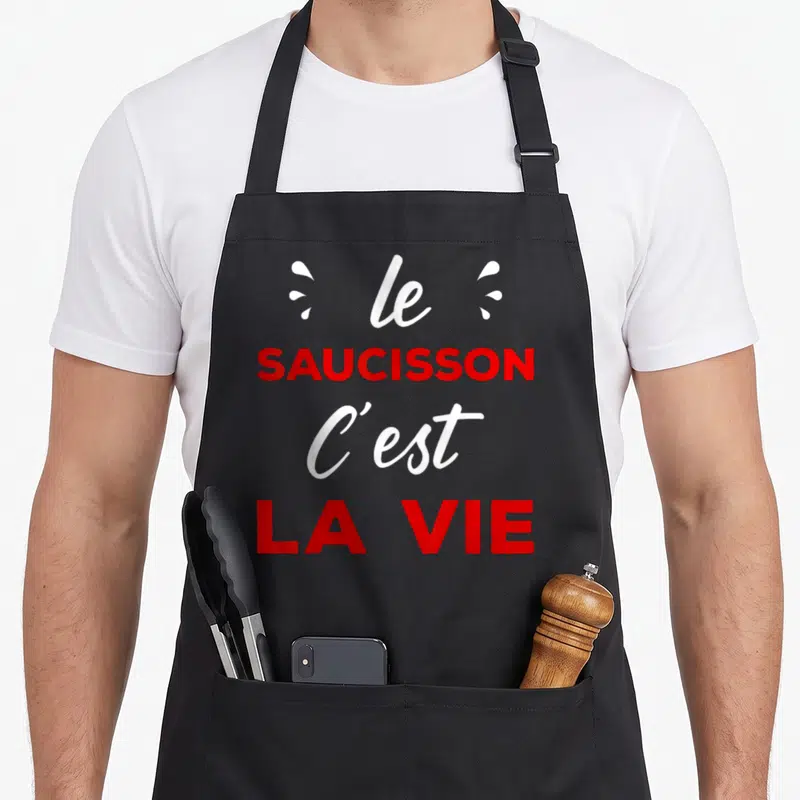 Tablier de cuisine noir avec l'inscription le saucisson c'est la vie en typographie rouge et blanche.