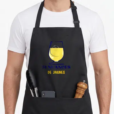 Tablier de cuisine noir avec illustration d'un verre de bière jaune et texte 51 nuances de jaunes en bleu et jaune.