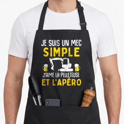 Tablier de cuisine noir avec une pelleteuse blanche encadrée par deux verres de bière et du texte jaune et blanc.