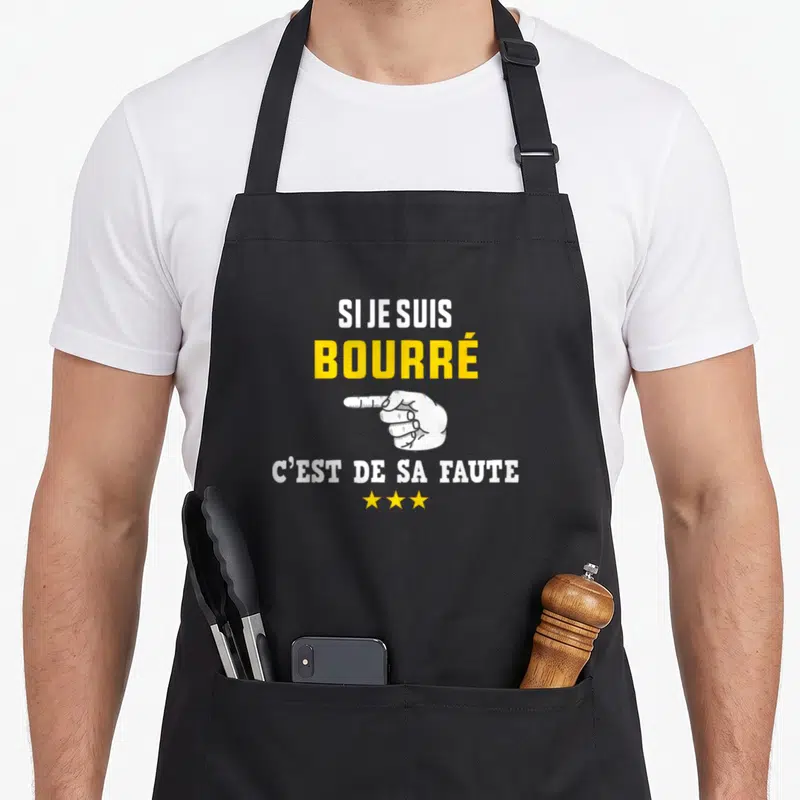 Tablier de cuisine noir avec inscription Si je suis bourré c'est de sa faute et une main blanche pointant vers la droite.