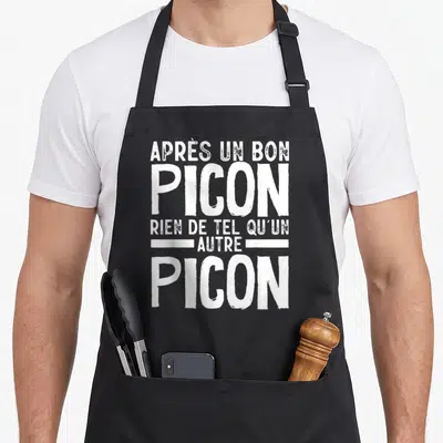 Tablier de cuisine noir avec inscription blanche « Après un bon Picon rien de tel qu'un autre Picon » en typographie stylisée.