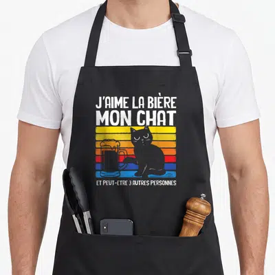 Tablier de cuisine noir avec un chat gris posant sa patte sur une bière et du texte humoristique en blanc.