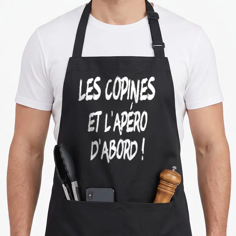 Tablier de cuisine noir avec l'inscription blanche Les copines et l'apéro d'abord en typographie style pinceau.