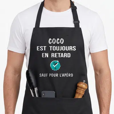 Tablier de cuisine noir avec inscription blanche Coco est toujours en retard sauf pour l'apéro et un logo de cocktail turquoise.