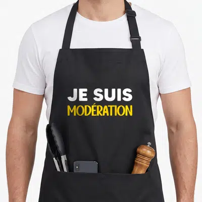 Tablier de cuisine noir avec l'inscription Je suis modération en lettres blanches et jaunes au centre.