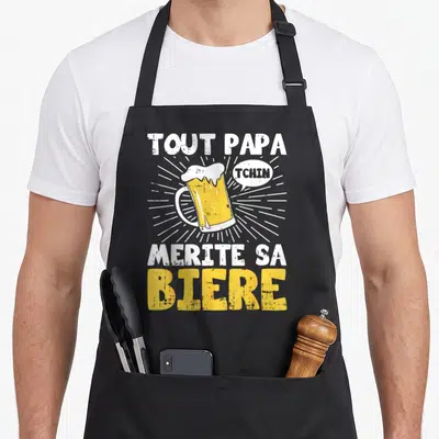 Tablier de cuisine noir avec illustration de verre de bière et texte Tout Papa Mérite Sa Bière TCHIN en blanc et jaune.