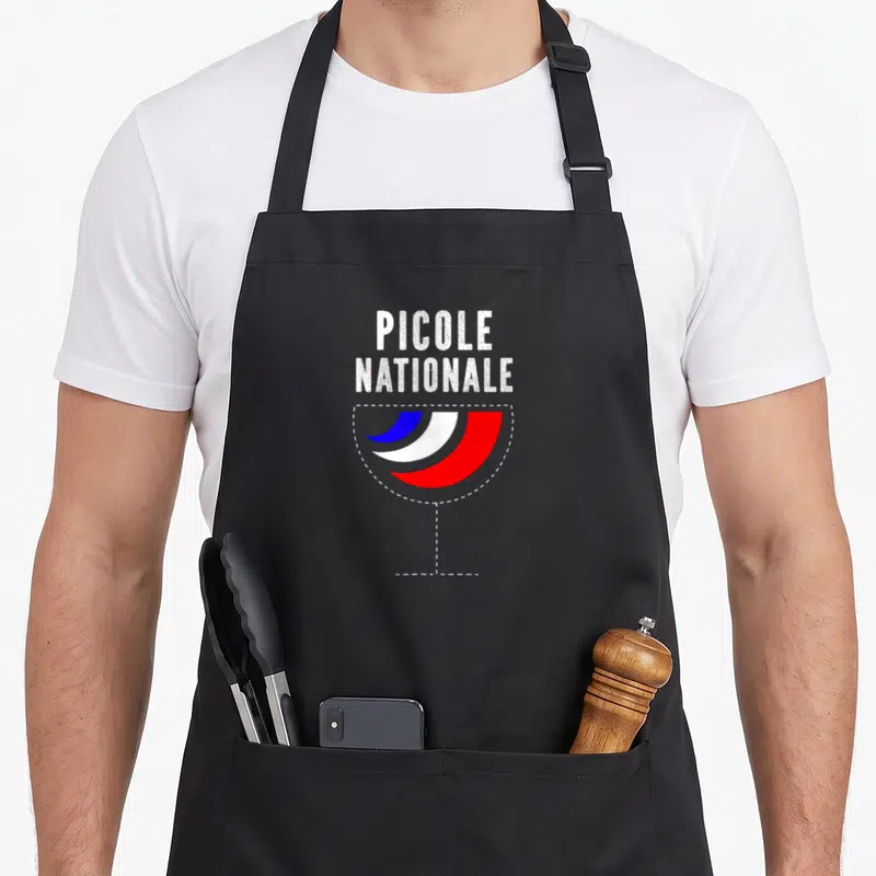 Tablier de cuisine noir avec illustration verre tricolore et texte Picole Nationale en blanc.