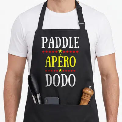 Tablier de cuisine noir avec inscription Paddle Apéro Dodo et étoiles rouges et jaunes.