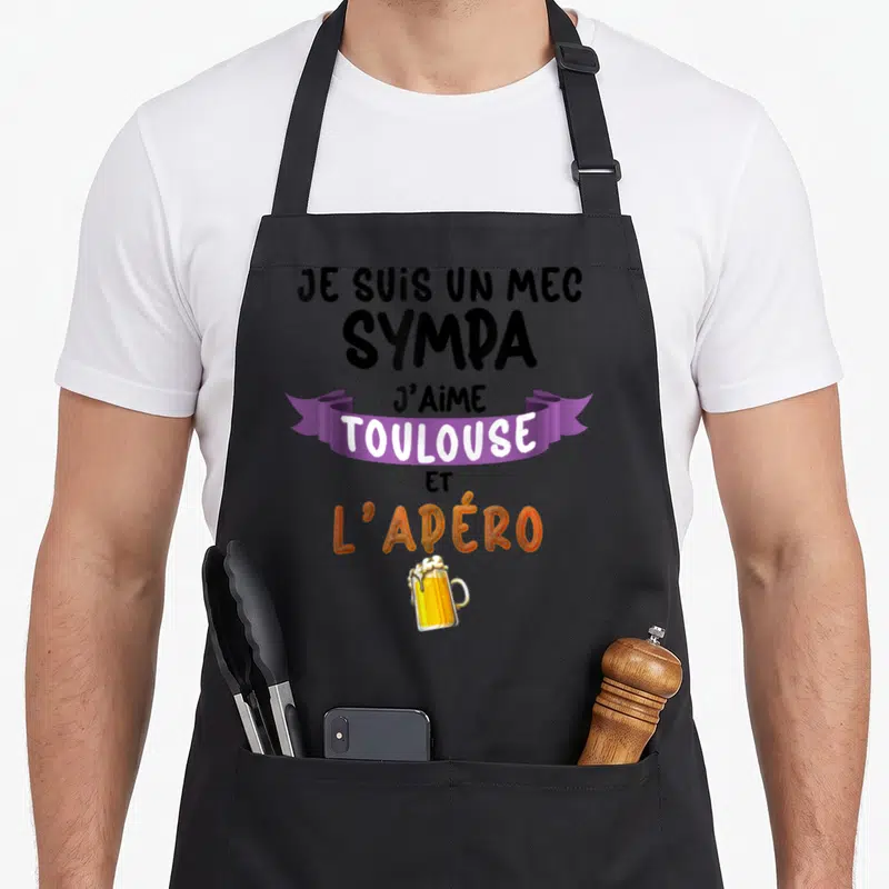 Tablier de cuisine noir avec texte Je suis un mec sympa Toulouse et l'apéro sur fond gris uni