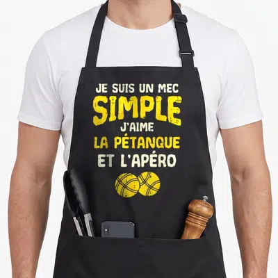 Tablier de cuisine noir avec texte jaune et blanc Je suis un mec simple j'aime la pétanque et l'apéro et deux boules de pétanque en bas.