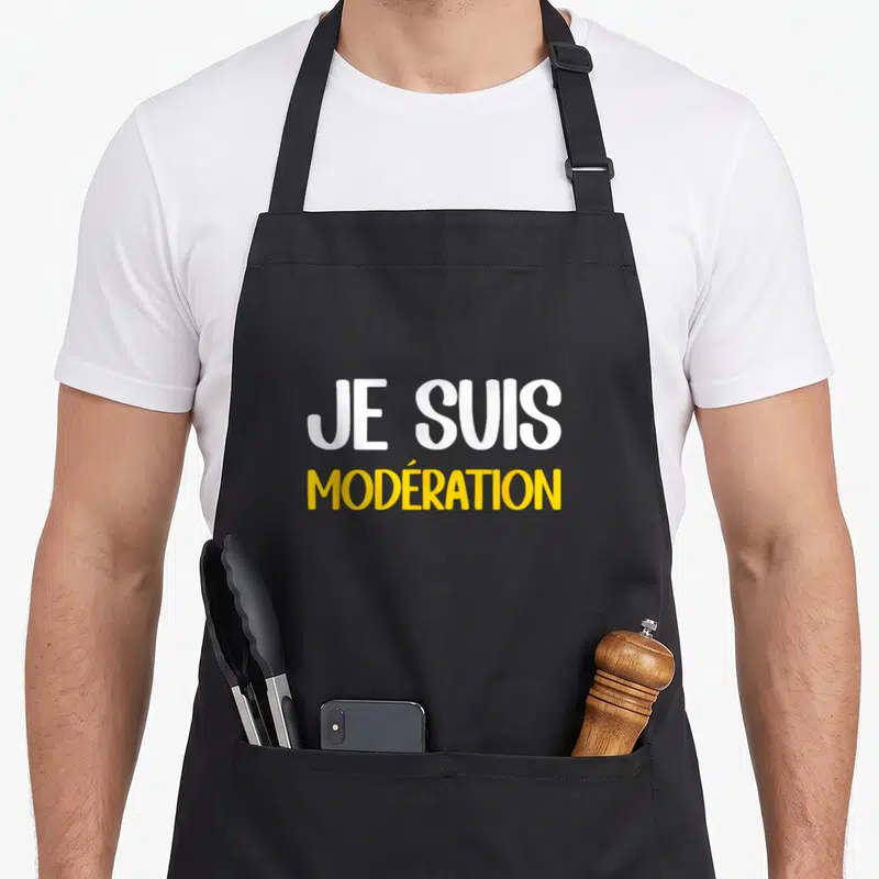Tablier de cuisine noir avec le texte Je Suis Modération imprimé en blanc et jaune au centre.