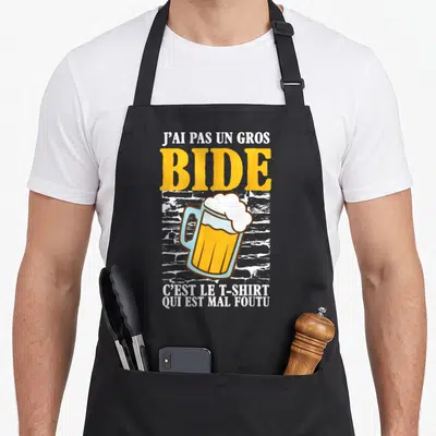 Tablier de cuisine noir avec illustration de verre de bière et texte humoristique en jaune et blanc.