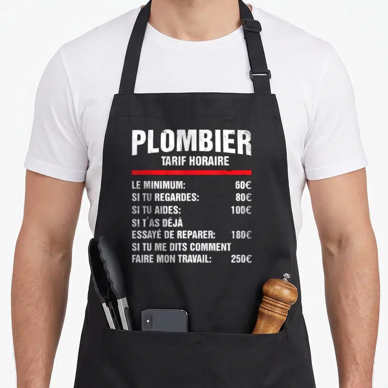 Tablier de cuisine noir avec un tarif horaire de plombier humoristique en typographie blanche et une ligne rouge distinctive.