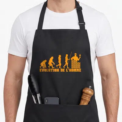 Tablier de cuisine noir avec silhouette orange évolution homme maçon bâtissant mur brique