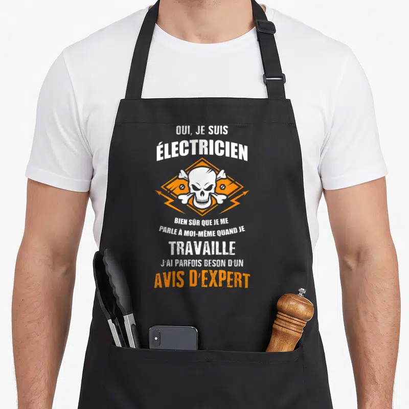 Tablier de cuisine noir avec un crâne orange et blanc et le texte Je suis électricien avis d'expert