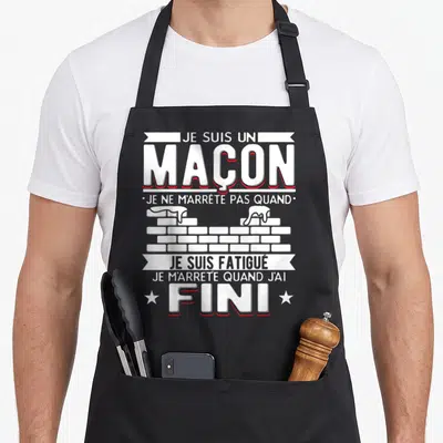 Tablier de cuisine noir avec inscription Je suis un maçon et illustration de mur en briques blanches.