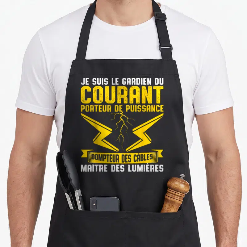 Tablier de cuisine noir avec inscription Je suis le gardien du courant et éclair jaune stylisé au centre.