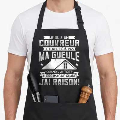Tablier de cuisine noir avec texte blanc « Je suis un couvreur » et dessin de maison stylisé au centre.