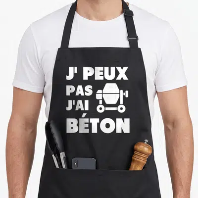 Tablier de cuisine noir avec inscription blanche J'peux pas j'ai béton et illustration de bétonnière.