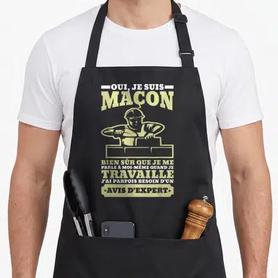 Tablier de cuisine noir avec illustration d'un maçon et le texte Oui je suis maçon bien sûr avis d'expert en jaune et blanc.