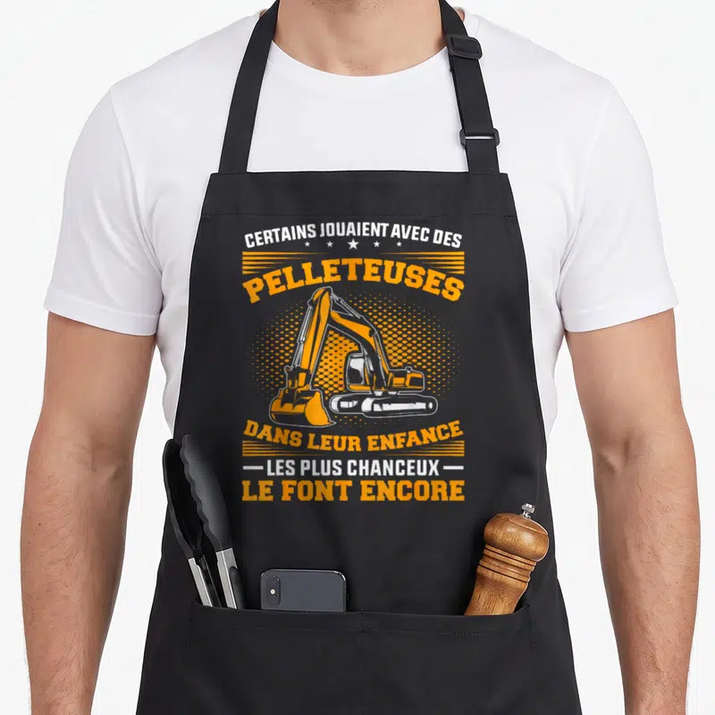 Tablier de cuisine noir avec illustration orange et texte sur les pelleteuses et l'enfance