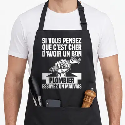 Tablier de cuisine noir avec une main tenant une clé à molette et le texte Si vous pensez que c'est cher d'avoir un bon plombier essayez un mauvais