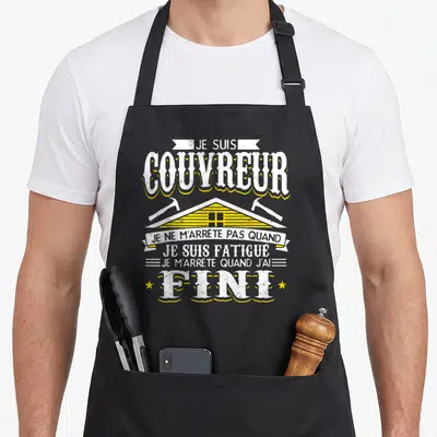 Tablier de cuisine noir avec illustration jaune et blanche d'une maison et texte sur le métier de couvreur.
