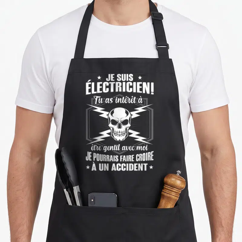 Tablier de cuisine noir avec un crâne blanc, des éclairs et le texte Je suis électricien à un accident.