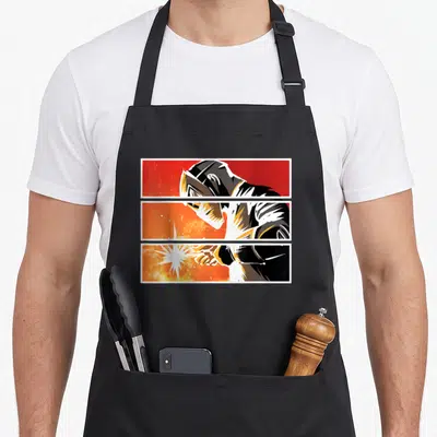 Tablier de cuisine noir avec illustration d'un soudeur en masque et éclats lumineux rouges oranges