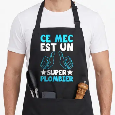Tablier de cuisine noir avec inscription Ce mec est un super plombier et deux mains faisant des pouces levés bleus.