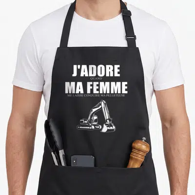 Tablier de cuisine noir avec l'inscription J'adore quand ma femme me laisse conduire ma pelleteuse et une excavatrice blanche.