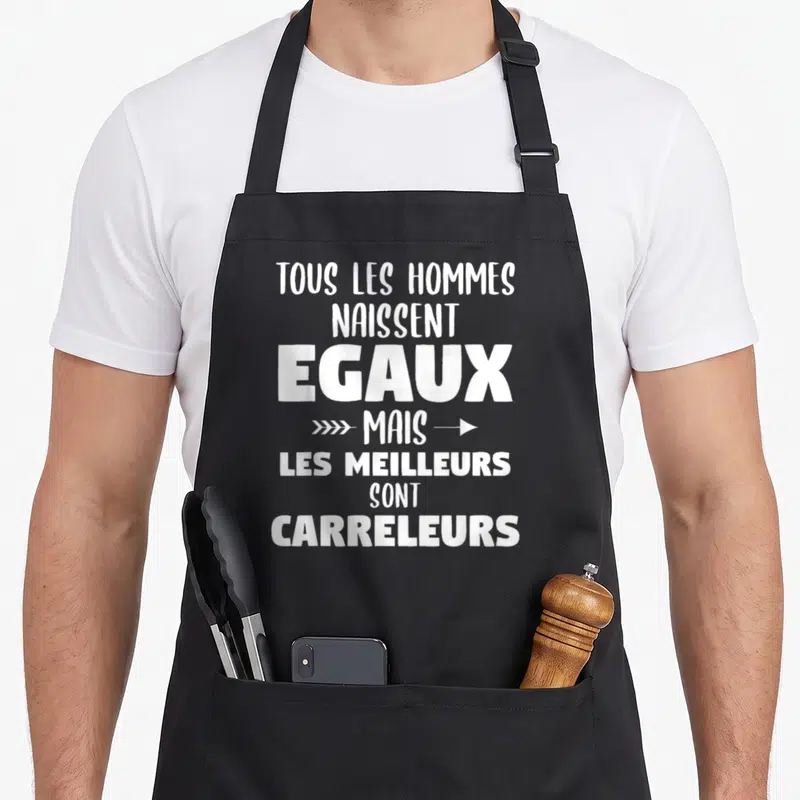 Tablier de cuisine noir avec inscription blanche Tous les hommes naissent égaux mais les meilleurs sont carreleurs et flèches décoratives.