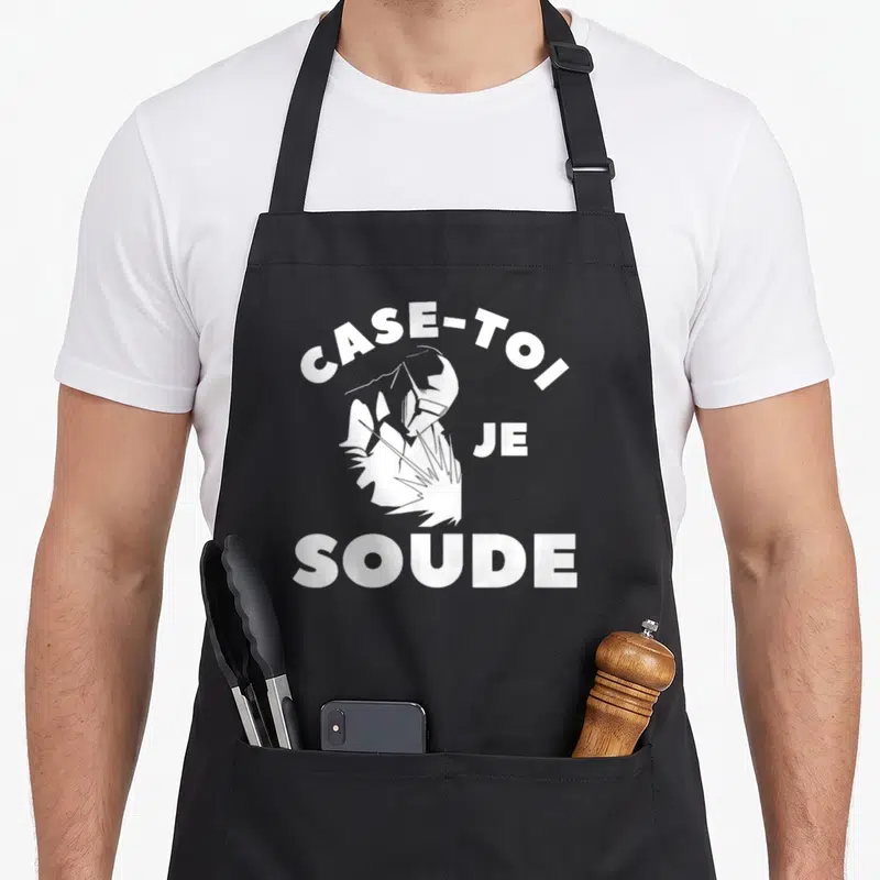 Tablier de cuisine noir avec l'illustration d'un soudeur et le texte Case-toi je soude en blanc.