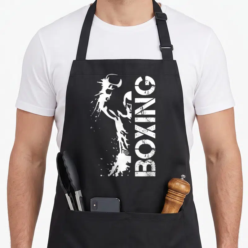 Tablier de cuisine noir avec illustration blanche d'un boxeur et l'inscription BOXING verticale.