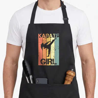 Tablier de cuisine noir avec silhouette femme karatéiste et texte Karate Girl sur fond de bandes orange jaune et bleu pastel