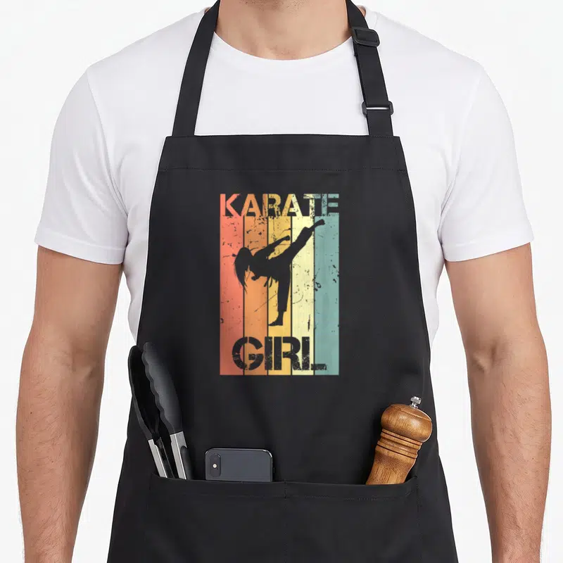 Tablier de cuisine noir avec silhouette femme karatéiste et texte Karate Girl sur fond de bandes orange jaune et bleu pastel