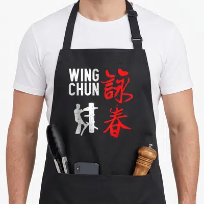 Tablier de cuisine noir avec silhouette blanche, texte Wing Chun et calligraphie rouge chinoise.