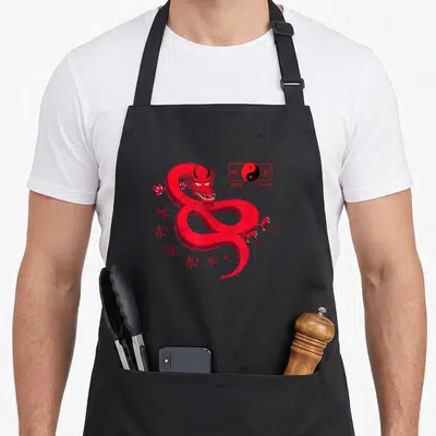 Tablier de cuisine noir avec un dragon rouge stylisé et le logo Wing Chun en haut à droite.