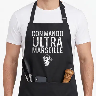 Tablier de cuisine noir avec texte blanc Commando Ultra Marseille et illustration de tête de mort coiffée d'un bonnet.