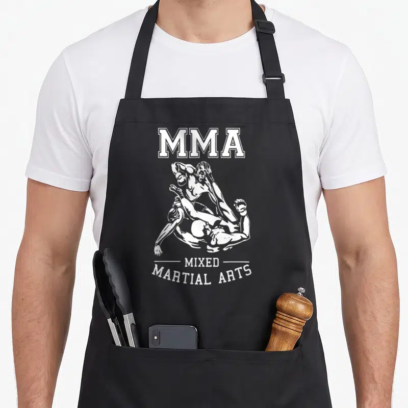 Tablier de cuisine noir avec une illustration blanche de deux combattants MMA et le texte Mixed Martial Arts en bas.