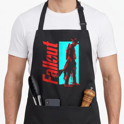 Tablier de cuisine noir avec une silhouette de Ghoul en chapeau et le mot Fallout en lettres rouges stylisées.