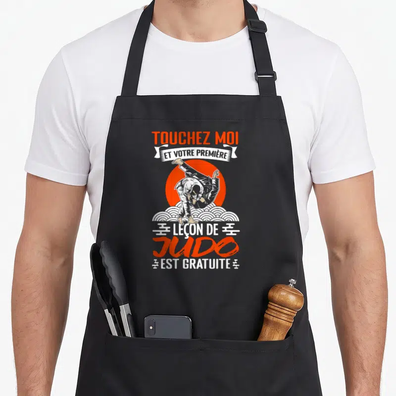 Tablier de cuisine noir avec inscription Touchez Moi et illustration de deux judokas en prise sur fond orange.