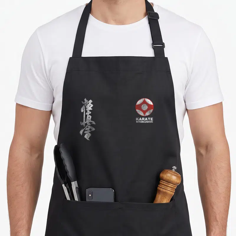 Tablier de cuisine noir avec calligraphie japonaise blanche et logo circulaire rouge KARATE KYOKUSHIN sur le devant.