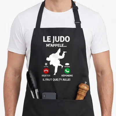 Tablier de cuisine noir avec une silhouette de judoka et des icônes d'appel téléphonique blanc sur fond sombre.