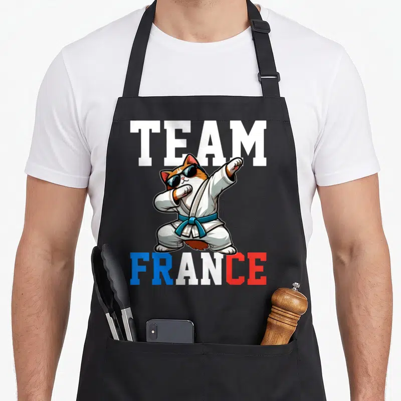 Tablier de cuisine noir avec un chat judoka en position de dab portant des lunettes noires et une ceinture bleue sous le texte Team France.