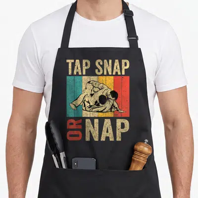 Tablier de cuisine noir avec illustration vintage de lutteurs et texte Tap Snap Or Nap.
