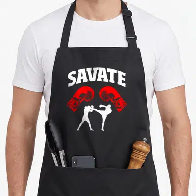 Tablier de cuisine noir avec linscription Savate, deux gants rouges et silhouettes blanches de combattants au centre.