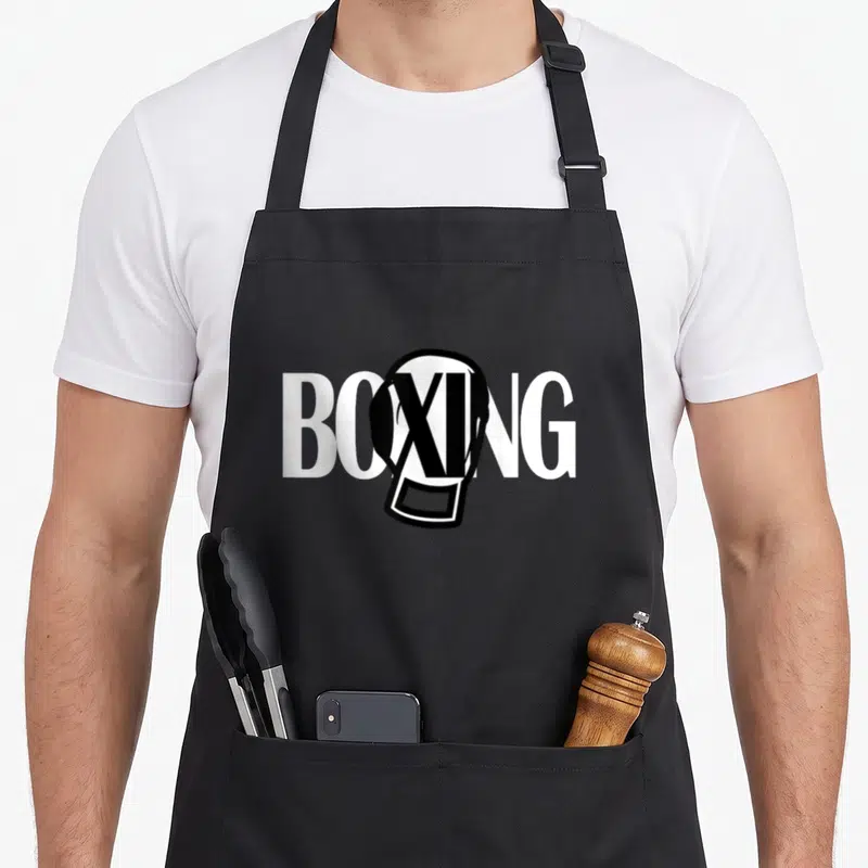 Tablier de cuisine noir avec inscription BOXING et gant de boxe blanc intégrant un L stylisé en croix.